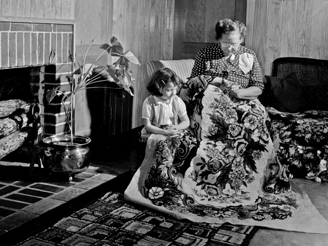 Grandmother making a rug with her grandchild looking on in Mt. Hope, AL, in 1953. (Progressive Farmer image by Jack Goodson)